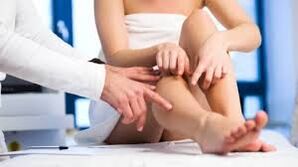 Doctor checking patient's legs